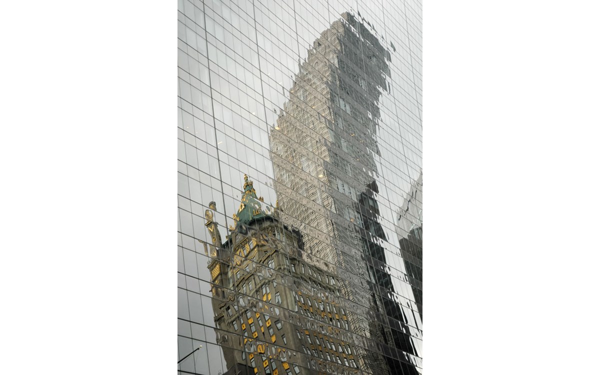 A distorted reflection coming from two opposite buildings on a glass facade of another building
